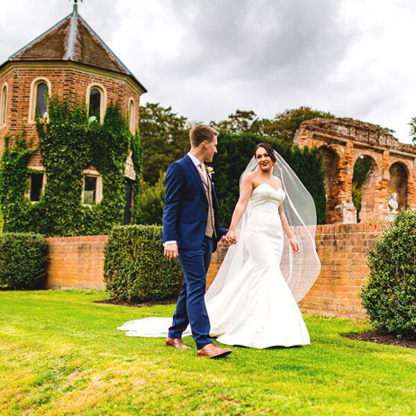 The bride and groom enjoy a strolll through the beautiful gardens at this wedding venue in Norfolk